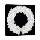 A square black canvas wall art print featuring an intricate white filigree wreath with a bow, photographed against a plain white background.