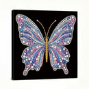 A square canvas wall art print featuring a large butterfly made of colorful rhinestones and beads on a black background, shown at a slight angle against a white studio backdrop.