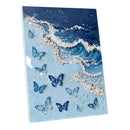 A square canvas wall art print featuring a stylized ocean wave with white pearl-like accents and multiple blue butterflies on a light blue background, shown at a slight angle against a white studio background.