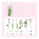 A sheet of floral sticker decals featuring pink and yellow tulips, roses, and green leaves, with decorative French text labels and a small package header card on a light pink background.