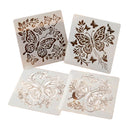 Four square white stencils or templates with butterfly and floral cutout designs, arranged on a plain white background.