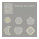 A digital preview sheet showing a soft misty floral pattern set, with the title 'Soft misty floral pattern' and a sample card labeled 'Many Crystal Gauge.' Below, six floral frame designs are displayed on a gray background: a circle, hexagon, clover, crescent moon, heart, and quatrefoil.