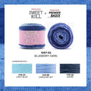 Yarn product card showing a ball of Premier Sweet Roll yarn and a matching skein of Premier Basix yarn in the shade Blueberry Swirl. The card includes a pink Premier Sweet Roll label, product text, and three coordinating color swatches labeled Light Blue, Carolina Sky, and Azure, all set against a blue knitted border.