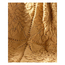 A close-up of a knitted textile with an intricate floral lace pattern in a warm camel brown color.