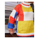 A close-up of a person wearing a chunky knit mock-neck sweater with large geometric color-block panels in yellow, white, red, and blue.