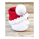 Side view of a Crocheted Santa Claus amigurumi on a wooden surface