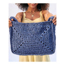 Woman holding a blue crocheted bag against a white background