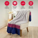 A chunky knit throw blanket draped over an armchair in a bright room, with four red circular feature icons at the top reading 100% Polyester,
