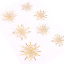 White paper stickers featuring gold and brown glittery snowflakes of various sizes, arranged diagonally on a white background.