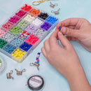 A person's hands are shown beading with colorful round beads and silver metal spring clips on a light blue surface, next to a large clear organizer filled with many bead colors.