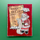 A festive Christmas card featuring a red textured background with a vintage-style 'Naughty or Nice List' scroll and an illustrated Santa Claus holding the list, photographed against a solid green background.