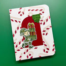 A handmade Christmas greeting card featuring a cartoon elf carrying wrapped presents, set against a large red letter 'A' with a green 'BELIEVE IN YOUR Elf' sticker, on a green background.