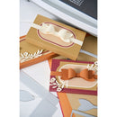 Decorative paper cutouts with bows and floral designs on a white surface