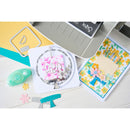 Card-making supplies including stamps, dies, and a card with floral design on a white surface.