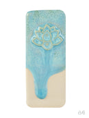 A rectangular ceramic tile featuring a light blue glazed lotus flower design on the upper half and a contrasting beige unglazed lower half, set against a plain white background.