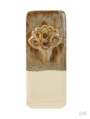 A rectangular ceramic tile or coaster with a glossy finish, featuring a textured brown and beige top half with an embossed gold lotus flower, and a smooth cream-colored bottom half.