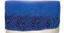 A square ceramic tile or coaster featuring a textured, porous blue glaze that fades into a smooth, solid deep blue at the top, with a light cream-colored base visible at the bottom.