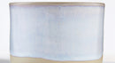 A close-up of a ceramic cup or vase with a light blue glazed finish and a natural beige unglazed base, shown against a plain white background.