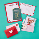 Set of Christmas-themed stationery items including cards and an envelope on a teal background.