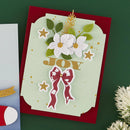A handmade layered greeting card with a red backing and a pale green front panel, decorated with white flowers, green leaves, gold stars, and a red bow, with the word "JOY" in gold. The card is photographed on a dark green background with a small portion of another card visible on the left.