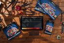 An ArtFinesse colored pencil set arranged on a rustic wooden table, with the open tray of black pencils in the center, matching product boxes around it, and several loose colored pencils placed around the scene. The boxes feature a colorful floral illustration and the ArtFinesse brand name.