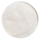 A circular close-up of a light off-white textured powder or granular material on a plain white background.