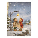 A vintage-style winter illustration showing two children standing on a snowy stone wall beneath a glowing streetlamp, looking up at snowflakes in a starry night sky. Snow-covered trees and small houses appear in the background.
