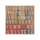 A square decorative cardstock featuring distressed block letters from A to Z arranged in rows on a textured background with warm brown, rust red, and muted green tones.
