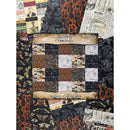A Halloween-themed patchwork quilt or fabric collection display featuring multiple patterned panels in black, orange, brown, and white, with collage-style newspaper and vintage ticket motifs. A central label reads 'Tim Holtz Idea-Glowy' and 'Palestine Collection Halloween.