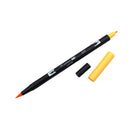 A black dual-tip marker pen with an orange tip, shown alongside its yellow cap and black end cap on a plain white background.