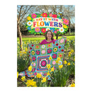 Woman holding a colorful quilt with flowers in a garden, featuring the 'Ringale' brand.