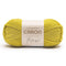 Ball of yellow yarn with Caron label on a white background