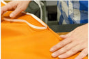 Person holding an orange bag with a strap, blurred background