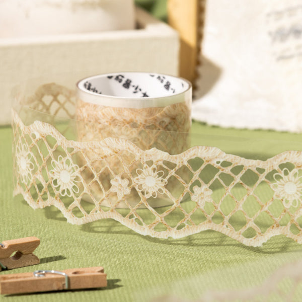 Decorative lace ribbon on a green surface with a blurred background