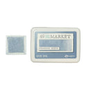 Manger 49 and Market Designer Denim dye ink pad shown with its white plastic packaging and a small sample stamp of the blue ink pad on the left.