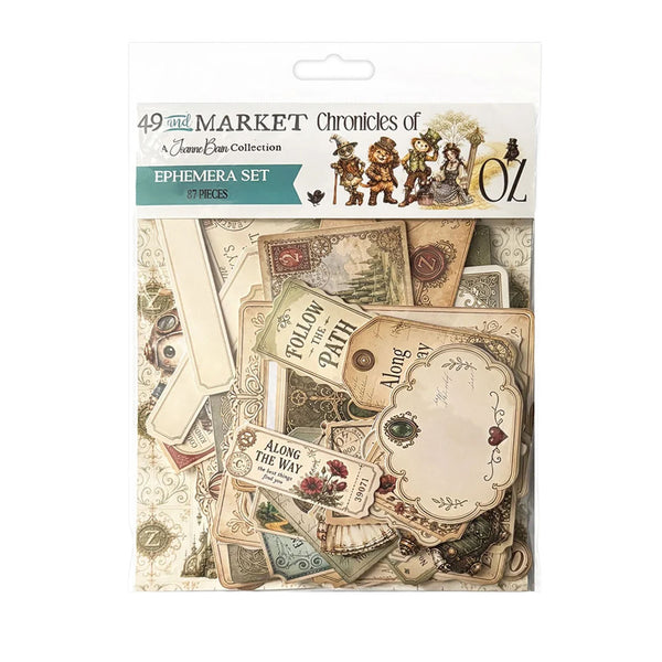 A packaged scrapbook ephemera set from the Clover Bean Collection, titled '49th Market Chronicles of Oz Ephemera Set'. The product contains 37 pieces of vintage-style paper in warm beige, brown, and muted teal tones, featuring labels, postcards, and decorative cutouts.