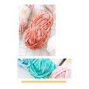 Two skeins of yarn, one pink and one green, on a white background.