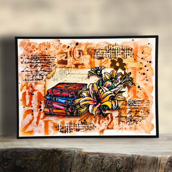 A framed mixed-media art print featuring a stack of colorful books and a large yellow-orange flower on an abstract orange, brown, and cream background with handwritten notes and musical staves. The print is displayed on a rustic wooden surface against a soft beige background.