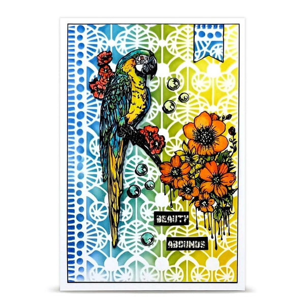 A square greeting card featuring a colorful parrot perched among orange flowers, with blue, green, and yellow gradient backgrounds and white ornamental cutout-style patterns.