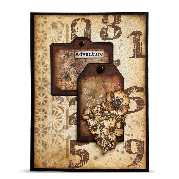 A square decorative art card or plaque with a vintage travel theme, featuring two layered paper tags with floral embellishments and the word 'Adventure' on a distressed beige background with large faded numbers.