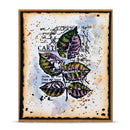 A square art print or card featuring a watercolor-style illustration of green and purple leaves over a distressed beige background with black script text and paint splatter details, framed by a dark border.