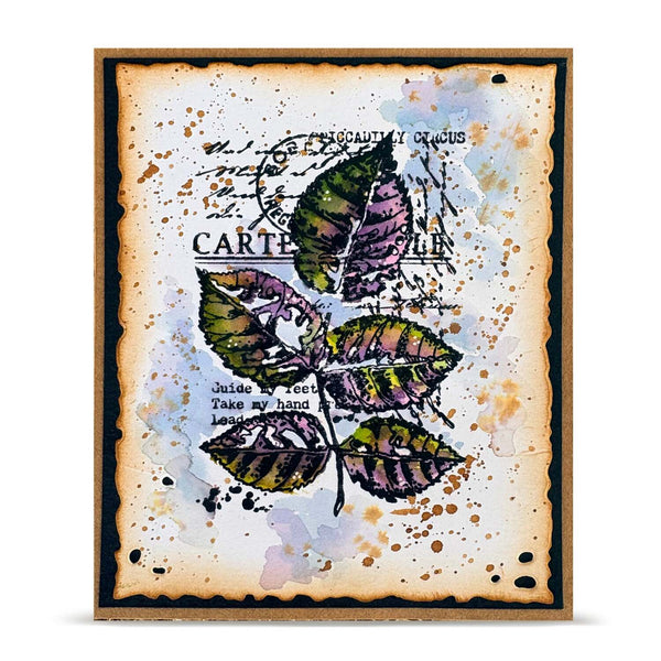 A square art print or card featuring a watercolor-style illustration of green and purple leaves over a distressed beige background with black script text and paint splatter details, framed by a dark border.