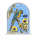 An arched decorative plaque or sign featuring a colorful parrot perched among yellow flowers on a light blue background, with a white stitched border and the word 'Unique' printed on a small black label.