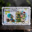 A rectangular handmade holiday card with a scalloped white border, featuring cartoon Christmas bird and cow characters, a decorated tree, and the text 'Have a moo-ry Christmas!' on a dark rustic background.