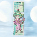 A vertical rectangular art print or card featuring a whimsical illustrated character wearing a pink robe and a decorated Christmas tree head, with pastel teal and cream layered background elements and text including 'the Halm', 'Cheers', and 'HOLY DONE'. The print is centered against a soft blue bokeh background.