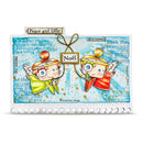 A square decorative card or art print featuring two illustrated cherub angels with wings, one in green and one in red, holding bows and a central tag that reads “Noël.” The background is a light blue distressed paper texture with musical notes and script text.