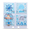 A square handmade collage card or scrapbook page featuring four light blue postage-stamp-like panels with winter-themed illustrations and text. The design includes a blue snowflake, a cartoon girl with a bow and flower, a circular stamp-style seal reading 'North Pole Toy Company,' postmark graphics, and small penguin and rabbit illustrations.