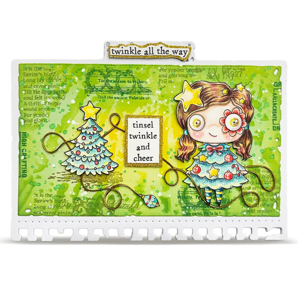 A square mixed-media art card or scrapbook paper featuring a whimsical Christmas illustration. The design shows a cartoon girl with brown hair, a flower in her eye, and a decorated Christmas tree, alongside text reading 'twinkle all the way' and 'tinsel twinkle and cheer'.