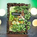 A handmade layered card featuring two cute cartoon birds in green and yellow, surrounded by 3D green leaves and a twig-style border. The card has a watercolor background with the words 'EMBRACE Please' written on it, set against a blurred background with warm bokeh lights.
