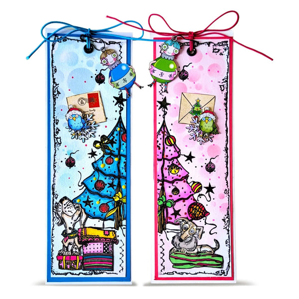 Two handmade Christmas-themed bookmark cards with colorful illustrations of trees, ornaments, envelopes, and playful characters, tied with blue and red ribbons on a white background.